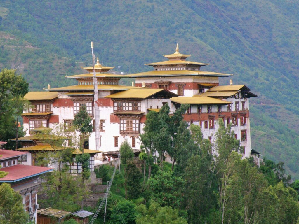 a large white and yellow building surrounded by trees