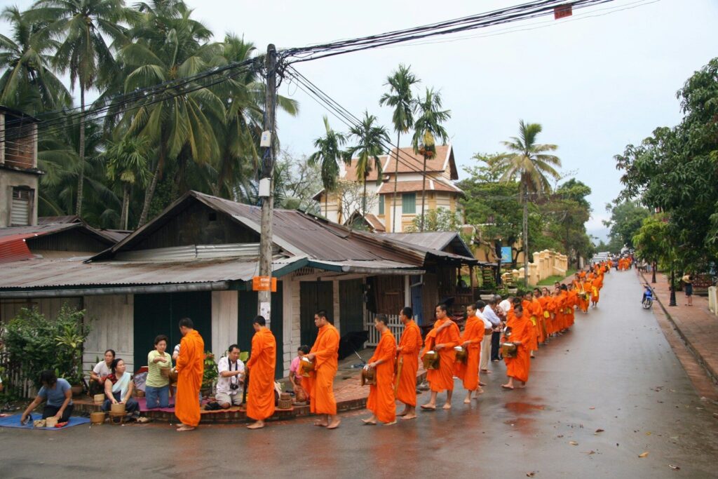 Buddhist monks receive alms in the early morning.