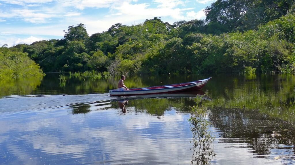 a man in a red and white boat on a river