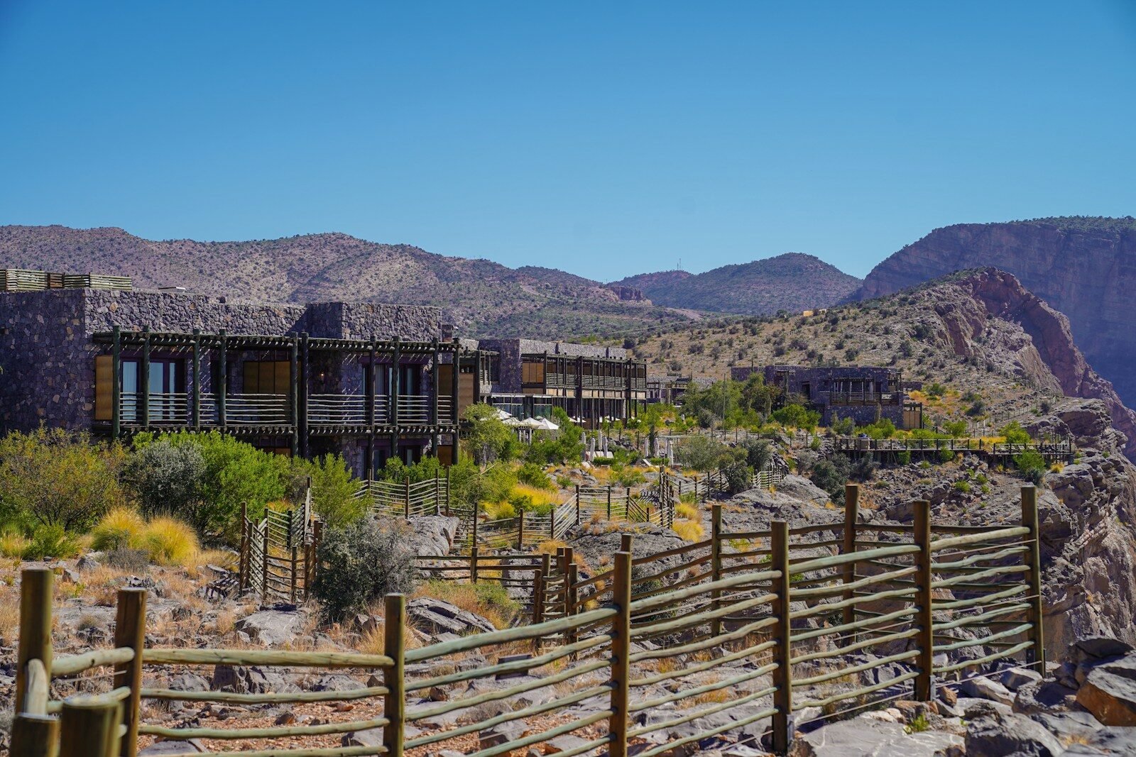 a wooden fence in front of a mountain